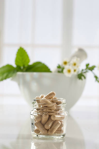 Herbal medicine pills and mortar over bright  background stock photo