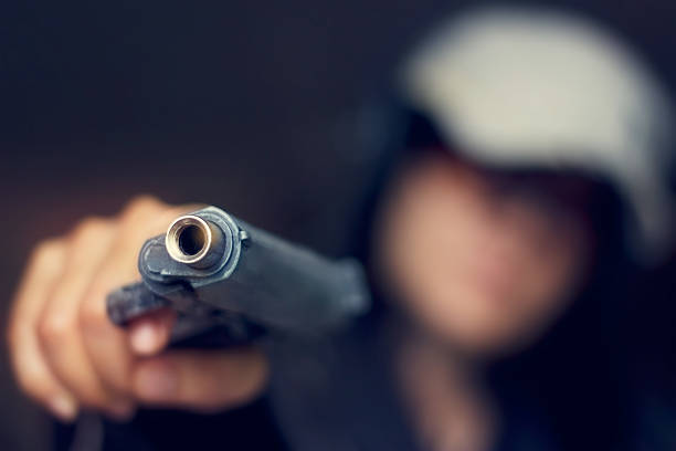 istock Woman pointing a gun at the target on dark background, 491405506