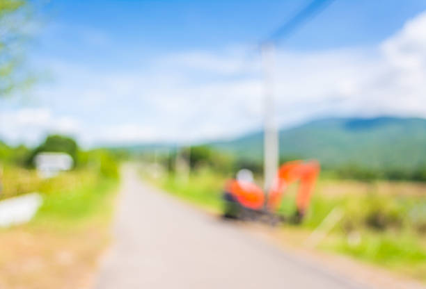 istock blur image of orange excavator doing road construction. 491406500