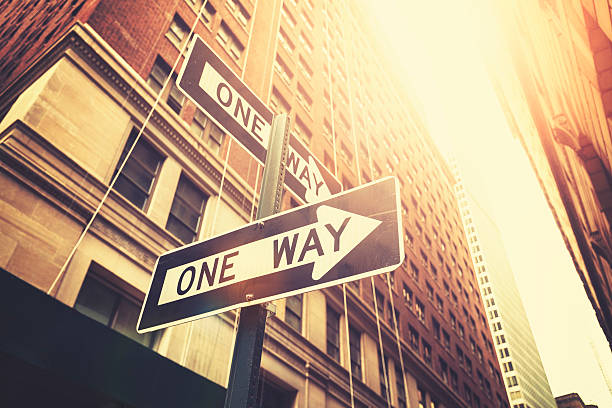 style rétro «aller simple» les panneaux de la rue de manhattan, à new york. - one way road sign sign street photos et images de collection