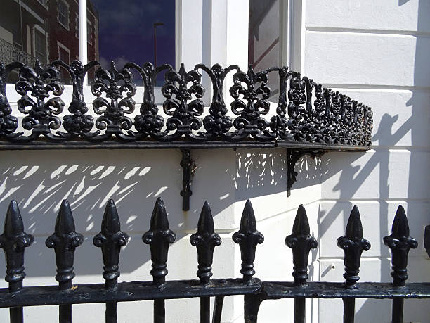 istock Image of ornate black iron railings against bay-window / white wall 491407362