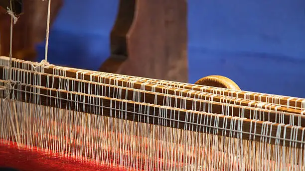 red and white colored weave on a loom
