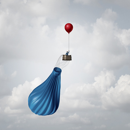 Emergency business plan and crisis management strategy metaphor as a businessman in a broken deflated hot air balloon being saved by a single small red party balloon as an innovative response solution idea.