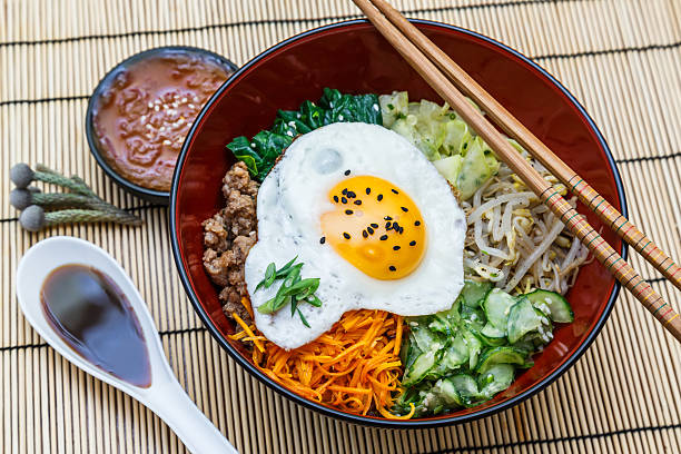 istock bibimbap in a bowl on bamboo mat, korean dish 491410892