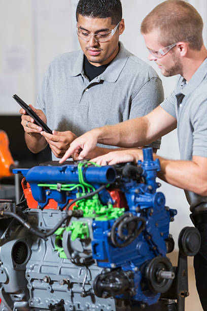 istock Two multi-racial men in auto mechanic school with engine 491411756