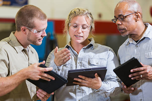 istock Team of repairmen talking and looking at digital tablets 491411970