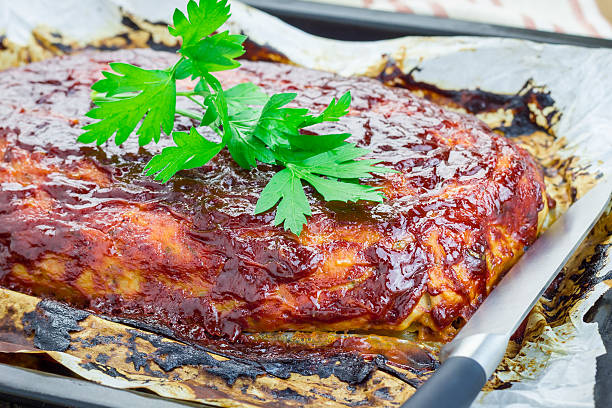 Homemade meatloaf with ketchup and parsley on a baking tray