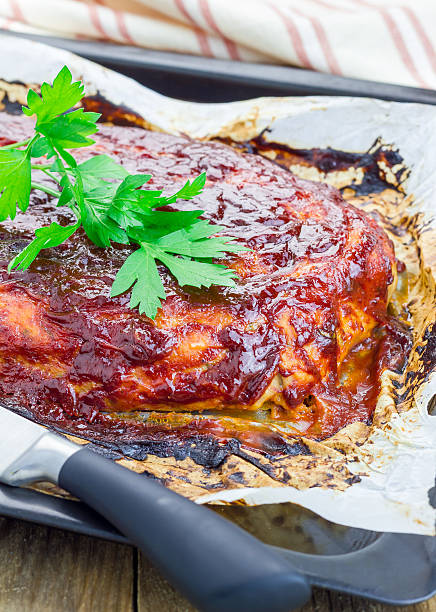 Homemade meatloaf with ketchup and parsley on a baking tray