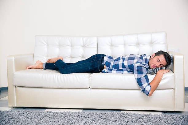 istock Man sleeping in cloth on the sofa at home 491424340