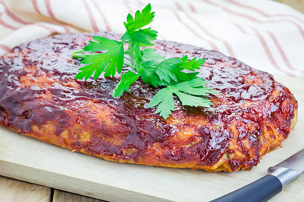 Homemade meatloaf with ketchup and parsley on a wooden board