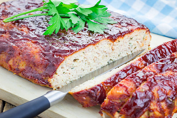 Homemade meatloaf with ketchup and parsley on a wooden board