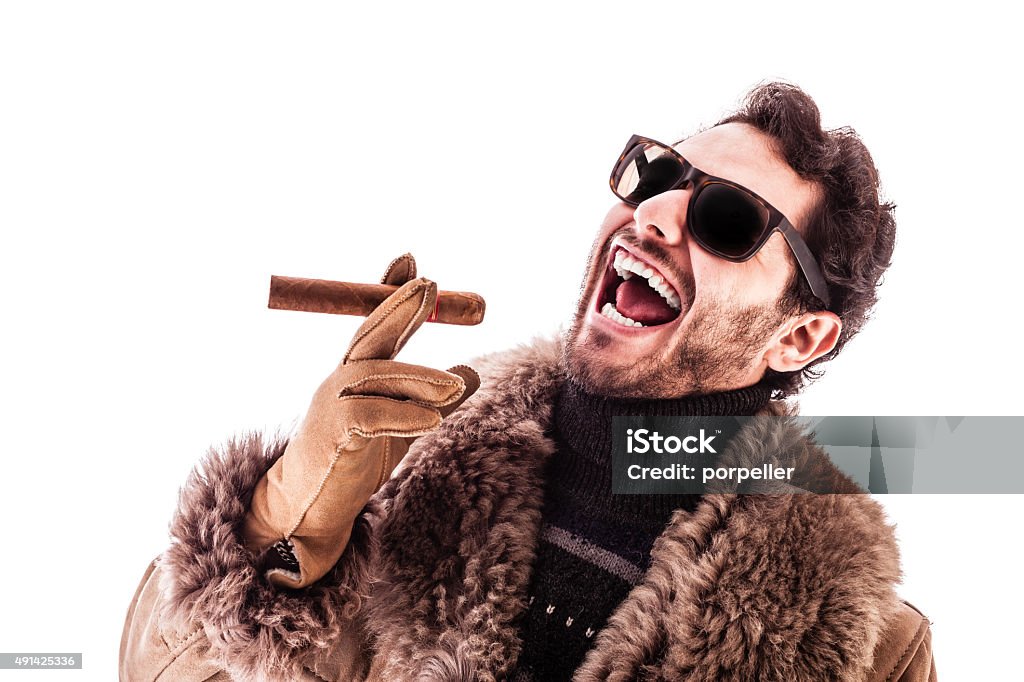 Hustler a young and rich man wearing a sheepskin coat isolated over a white background holding a cigar Wealth Stock Photo