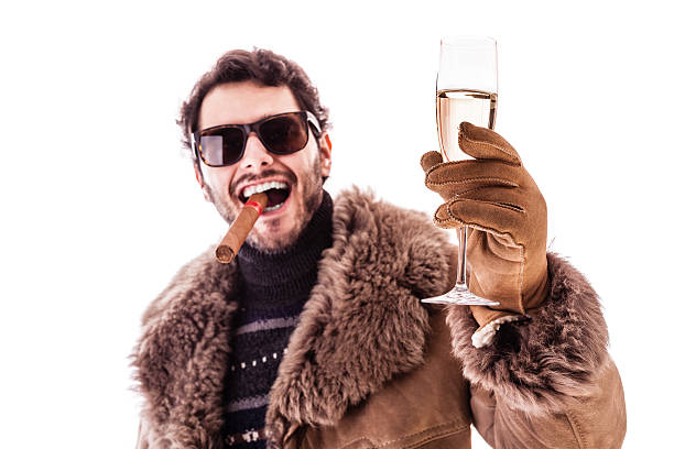 Toast! a young man wearing a sheepskin coat isolated over a white background holding a cigar and a glass with champagne prosperity stock pictures, royalty-free photos & images