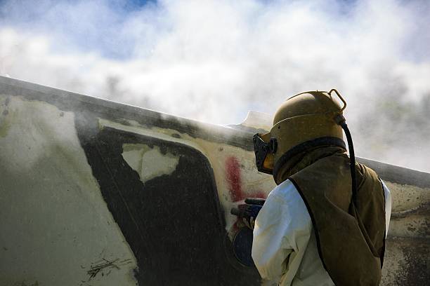istock Worker is remove paint by air pressure sand blasting 491426054