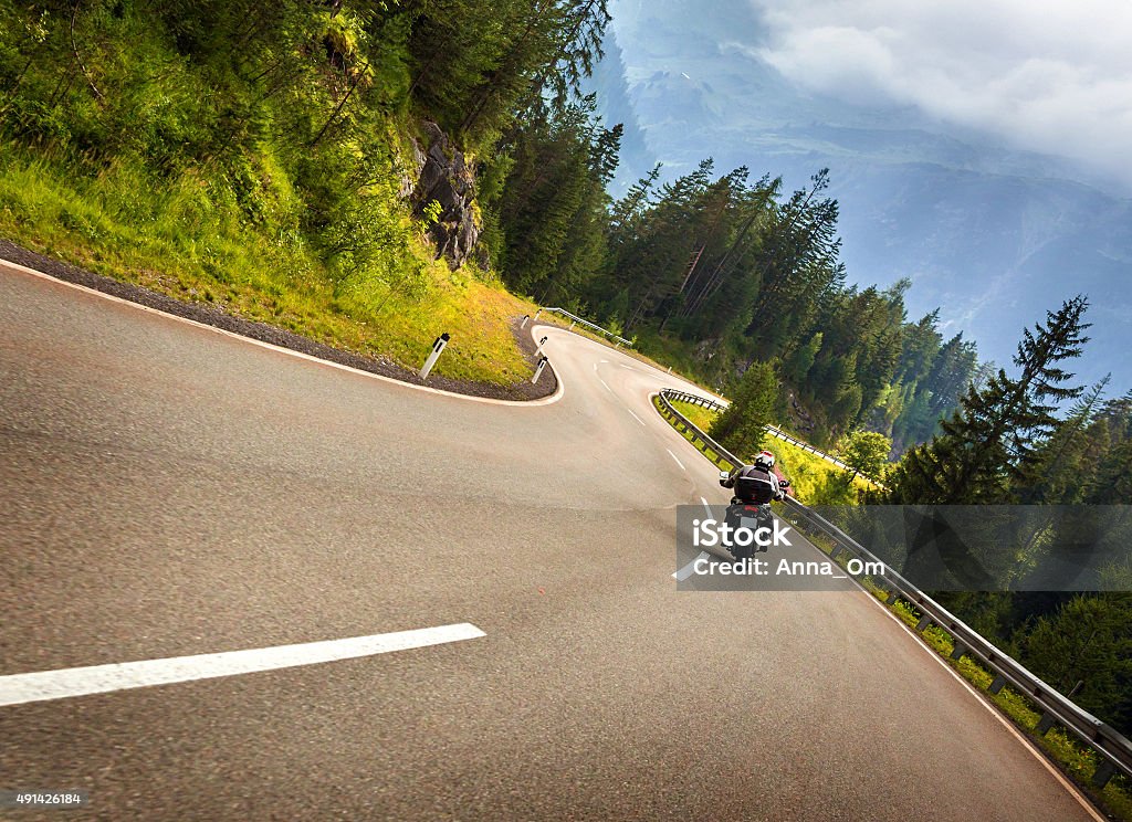 Biker in Austrian mountains Biker in Austrian mountains riding on curve road, Alps, Europe, speed and freedom concept, luxury transport, active travel and tourism Motorcycle Stock Photo