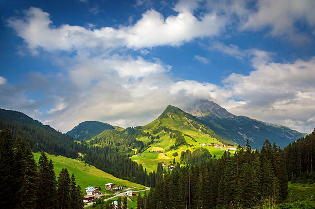 Little village in the mountains, fresh green valley, traditional mountainous buildings, Alps, Europe, summer vacation, travel and tourism concept