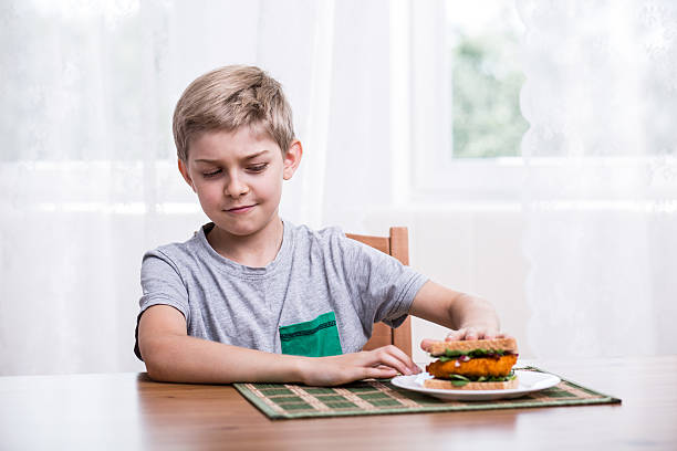 überladen kind mit hühnchen-sandwich - eating obsessive child toddler stock-fotos und bilder