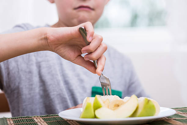 verärgert junge isst apfel - eating obsessive child toddler stock-fotos und bilder