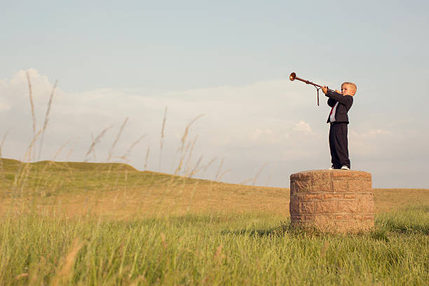 Young Boy Businessman Blows a Trumpet