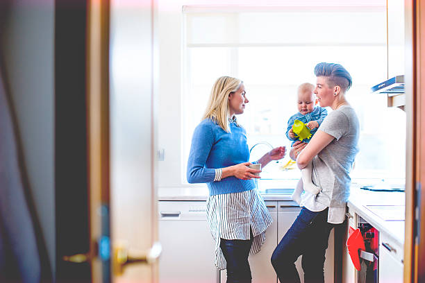 giovane coppia omosessuale con bambini piccoli in cucina - unknown gender foto e immagini stock