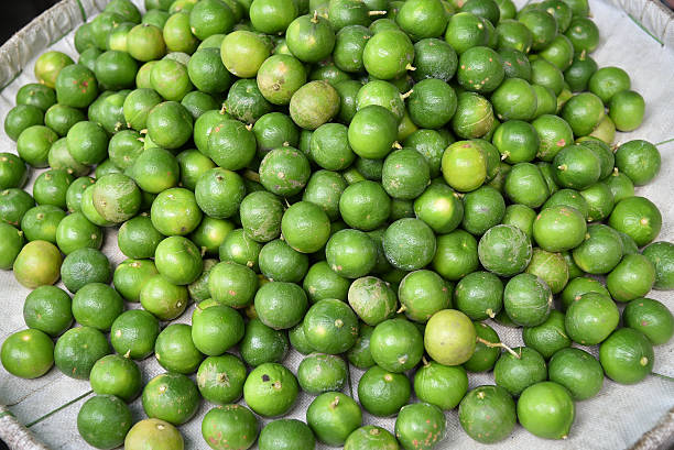 Stack of limes on display at market stock photo