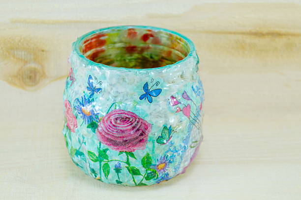 Decoupage decorated flower pattern jar on natural wooden background