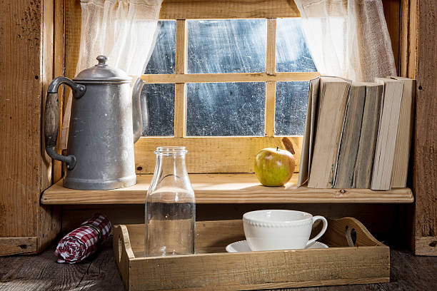 Old wooden cabin framed window with dark interior looking out into pure white background. Vintage, rustic wood theme.