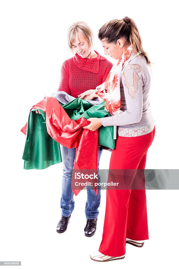 Seamstresses Choosing the fabric two seamstresses looking at different fabrics isolated over a white background 2015 Stock Photo