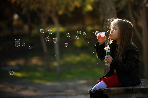 little girl in nature that bubbles