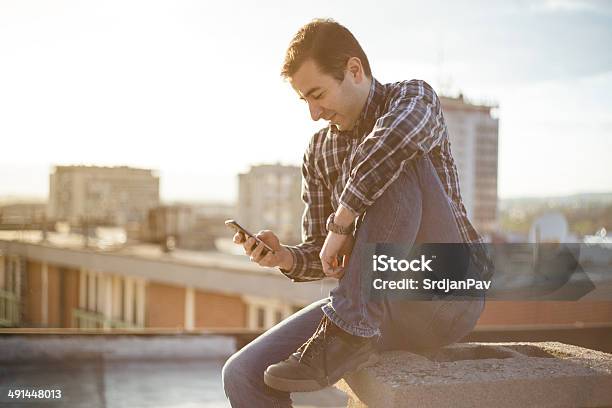 Urban Young Man Using A Smart Phone Stock Photo - Download Image Now - Adult, Adults Only, Attitude