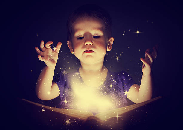 istock baby girl with magic book 491452371