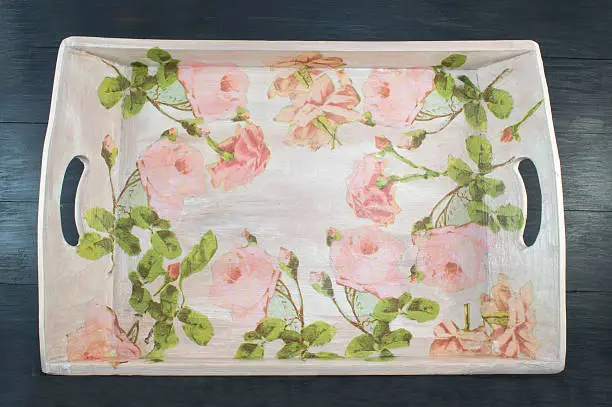 Photo of Decoupage decorated tray with flower pattern against  black wood
