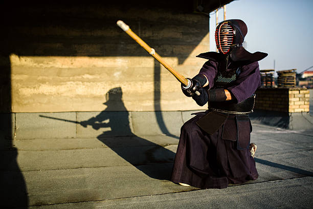 Kendo posing One person practicing traditional Japanese martial art Kendo on the roof. Sunset kendo stock pictures, royalty-free photos & images