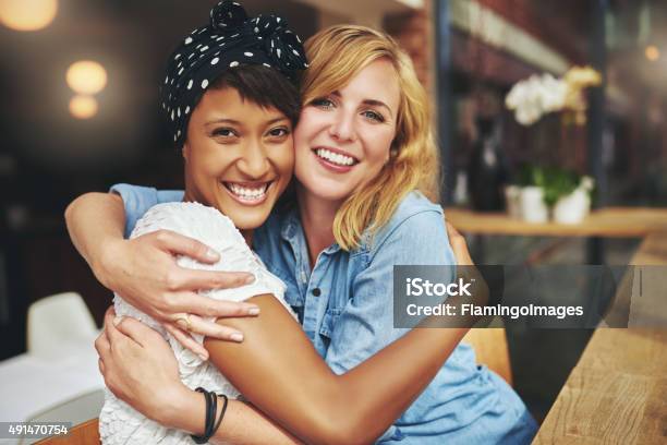 Two Happy Affectionate Young Woman Hugging Stock Photo - Download Image Now - Gay Couple, Girlfriend, Multiracial Group