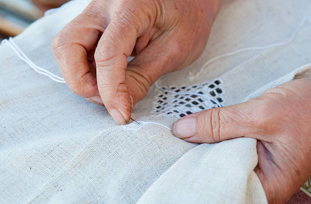 istock Senior Woman knitting a white fabric cloth 491471536