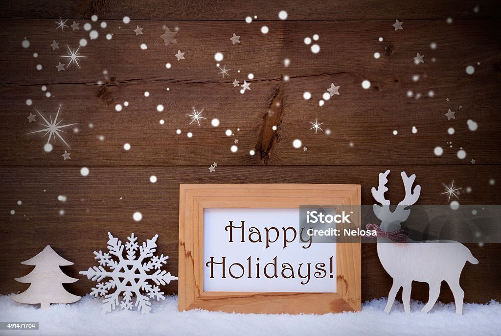 White Decoration On Snow, Happy Holidays, Sparkling Stars Christmas Card With Picture Frame On Snow, Snowflakes And Sparkling Stars. English Text Happy Holidays. White Christmas Decoration Like Snowflake, Tree And Reindeer. Wooden And Vintage Background Happy Holidays - Short Phrase Stock Photo