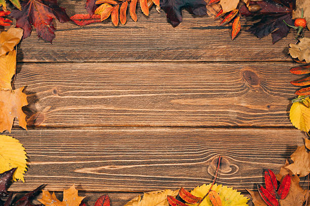 istock Background with wooden table and autumnal leaves 491484042