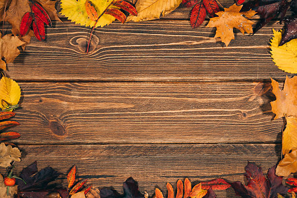 istock Background with wooden table and autumnal leaves 491484062
