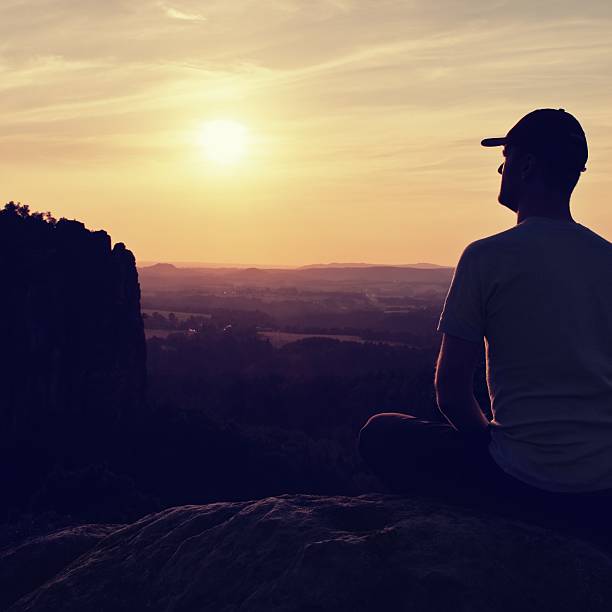 istock Man with baseball cap on mountain top. Silhouettes 491486482