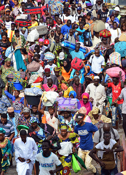 African crowd on the move Banjul, The Gambia: large crowd with luggage enters the ferry to Barra - many people, many logos - rush hour at the ferry terminal - photo by M.Torres banjul stock pictures, royalty-free photos & images