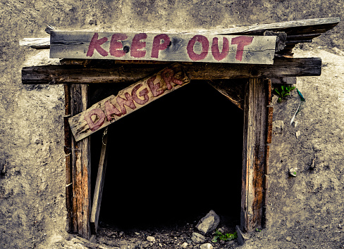 Conceptual Image Of A An Entrance To An Old Mine Tunnel With Keep Out And Danger Signs
