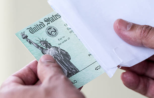 Tax refund Men hands holding a US Government Treasury check travel refund stock pictures, royalty-free photos & images