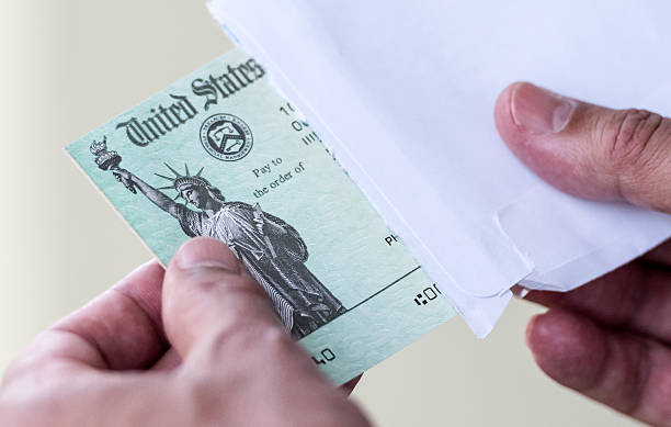 Tax refund Men hands holding a US Government Treasury check attraction studio photography stock pictures, royalty-free photos & images