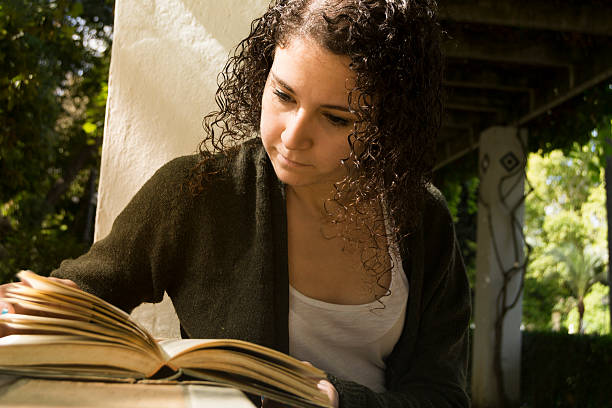 istock Young woman reading a book in autumn 491499100