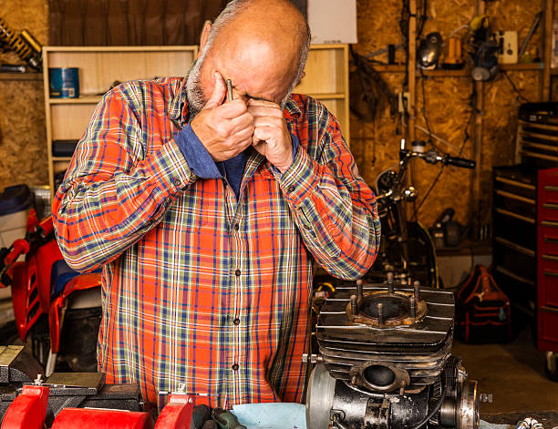 Man working in a garage with a eye injury
