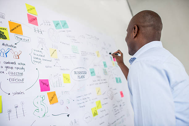 afroamerikanischer geschäftsmann zeichnet einen plan - business plan stock-fotos und bilder