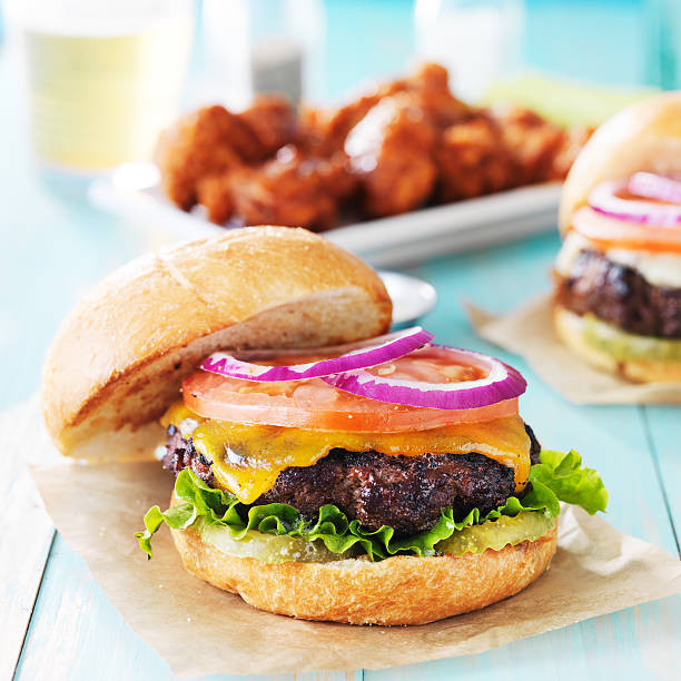 istock tasty cheeseburgers with wings and beer 491501084