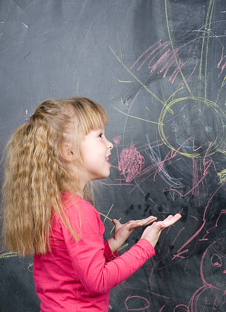 istock little cute girl in classroom at blackboard writing 491503280
