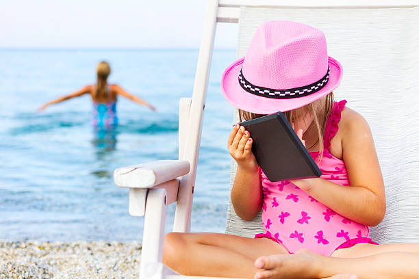 istock Child playing with technology while her mother goes swimming 491512252