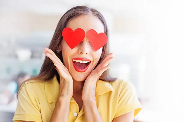 Photo of emoji concept: woman with the hearts instead of her eyes